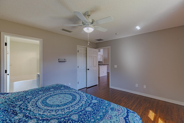 bedroom featuring baseboards, a textured ceiling, visible vents, and wood finished floors