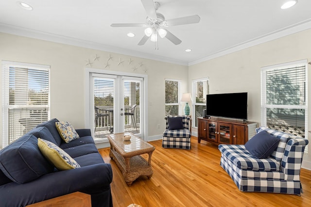 living room featuring ornamental molding, light wood-type flooring, french doors, and baseboards