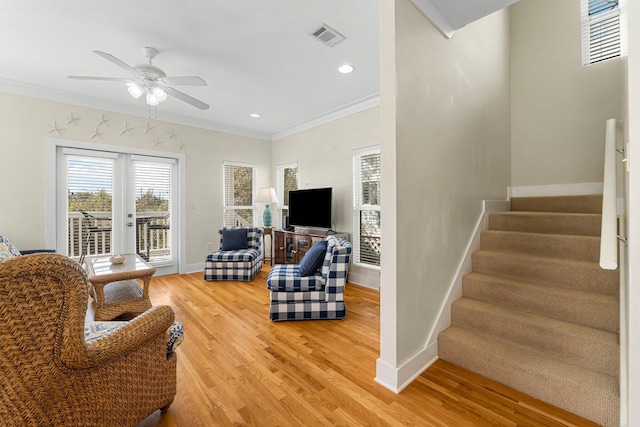 living room with ornamental molding, visible vents, stairway, and light wood finished floors