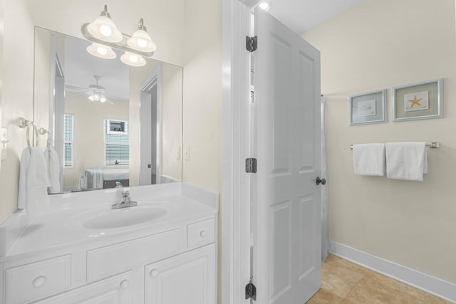 ensuite bathroom featuring connected bathroom, vanity, baseboards, a ceiling fan, and tile patterned floors