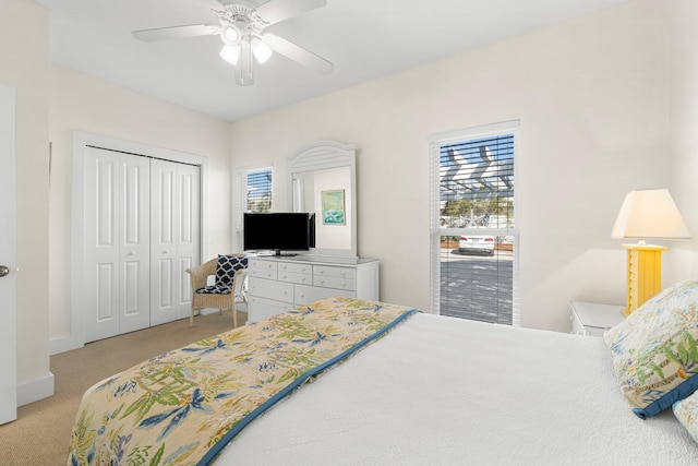 bedroom with light carpet, a closet, and a ceiling fan