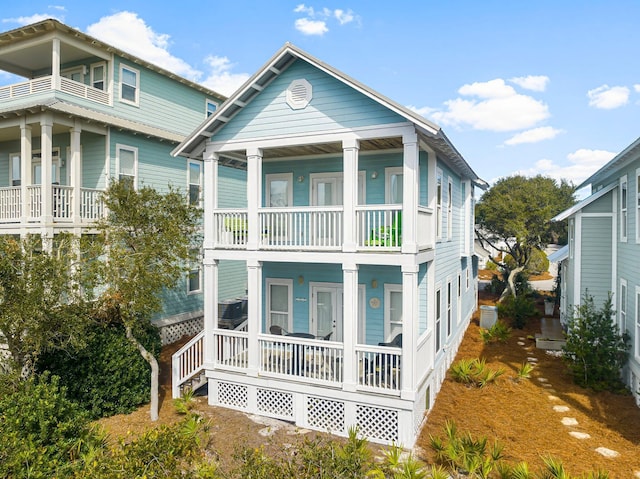 back of property featuring covered porch and a balcony