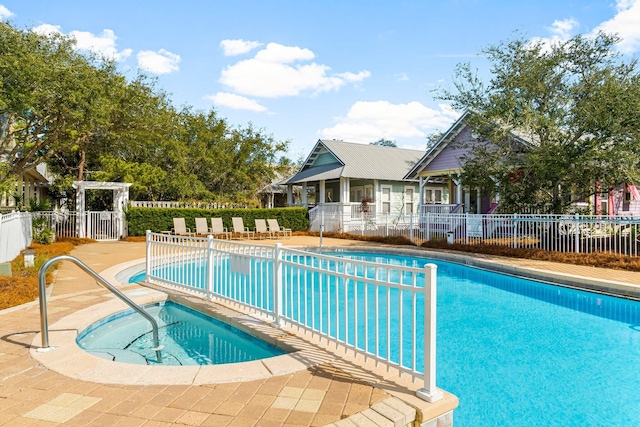 community pool featuring a patio area, fence, and a community hot tub