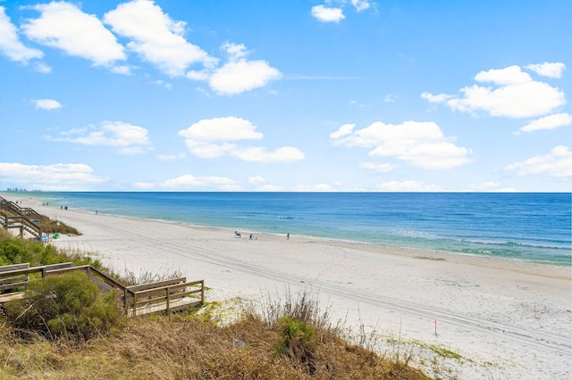 view of water feature featuring fence and a beach view