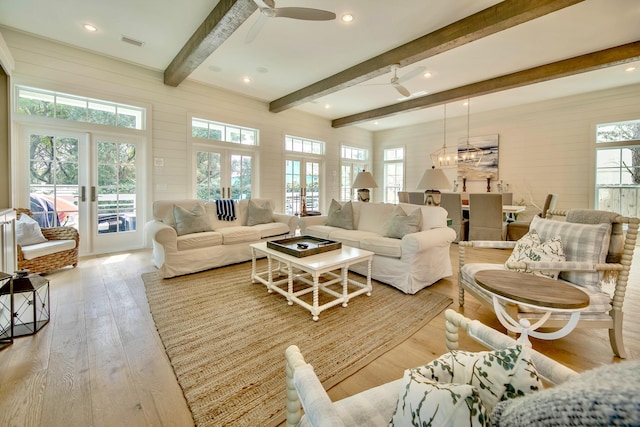 living area with light wood-type flooring, a wealth of natural light, french doors, and visible vents