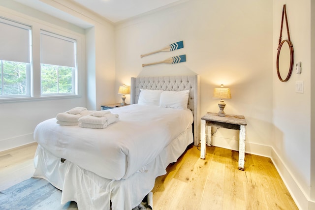 bedroom featuring baseboards and wood finished floors