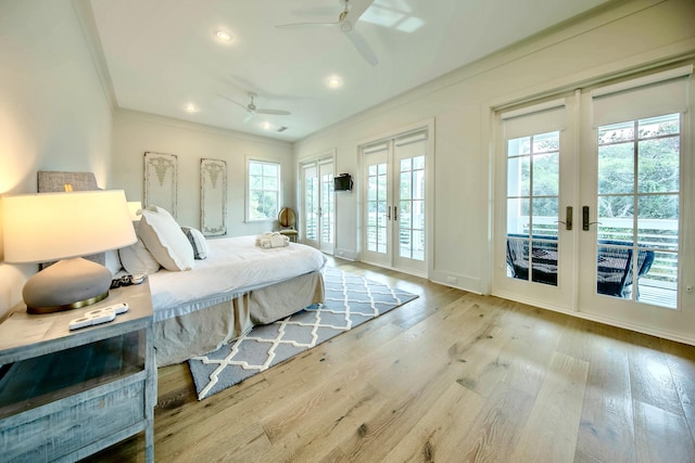 bedroom featuring baseboards, wood finished floors, access to outside, crown molding, and french doors