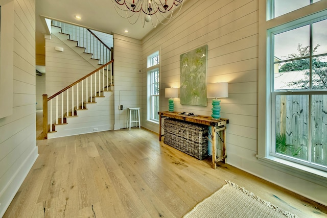 interior space featuring stairs, a notable chandelier, recessed lighting, wooden walls, and hardwood / wood-style flooring