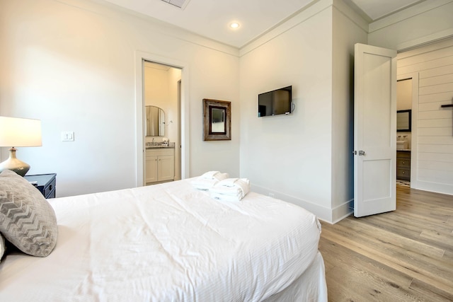 bedroom with light wood finished floors, baseboards, and crown molding