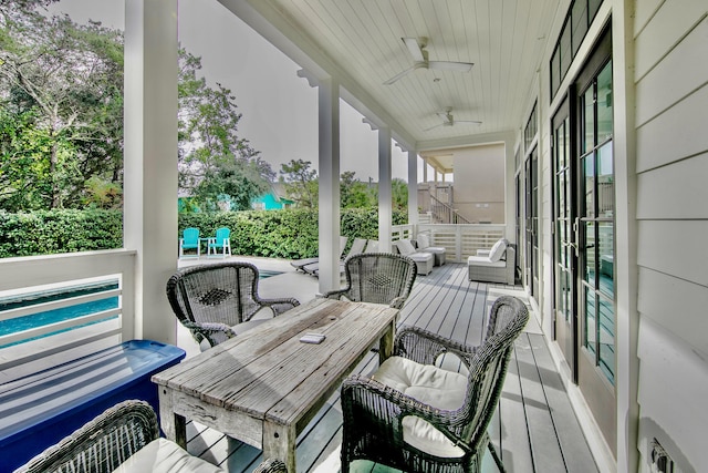 deck with an outdoor living space and a ceiling fan