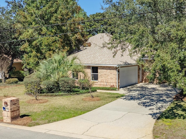 view of front of property featuring an attached garage, brick siding, a shingled roof, concrete driveway, and a front yard