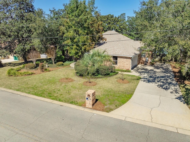 view of front facade featuring a front yard, roof with shingles, and driveway