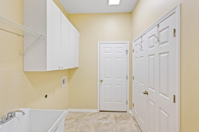 laundry area with baseboards, washer hookup, light tile patterned flooring, cabinet space, and a sink