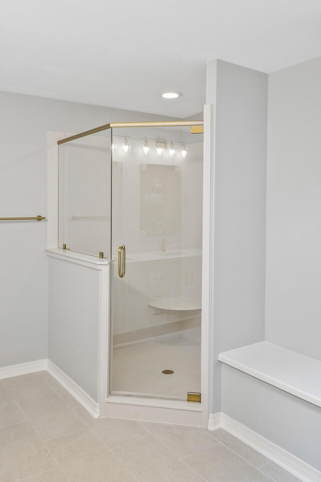 full bath featuring baseboards, a stall shower, and tile patterned flooring