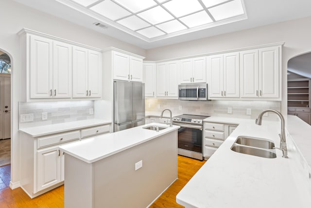 kitchen featuring a sink, visible vents, arched walkways, and appliances with stainless steel finishes