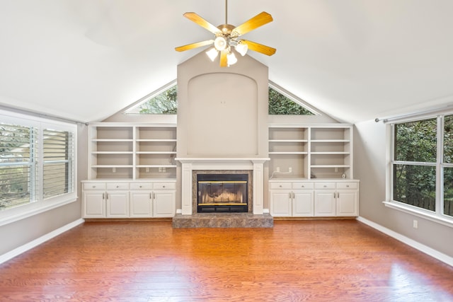 unfurnished living room with baseboards, light wood-style flooring, a fireplace, and vaulted ceiling