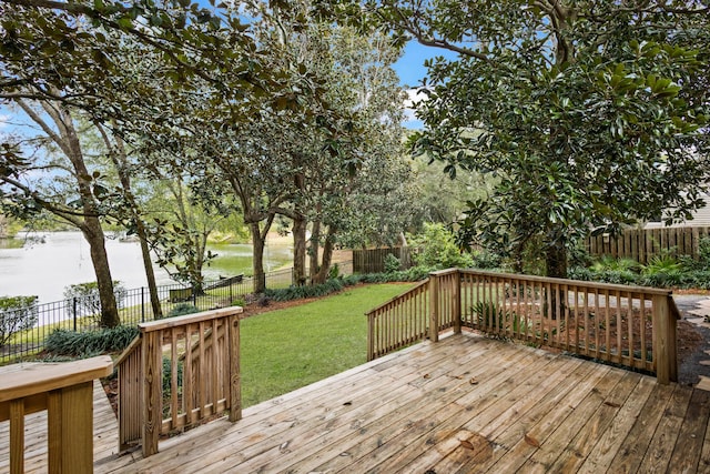 wooden terrace with a lawn, a fenced backyard, and a water view