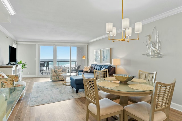 dining room featuring a notable chandelier, baseboards, ornamental molding, and wood finished floors