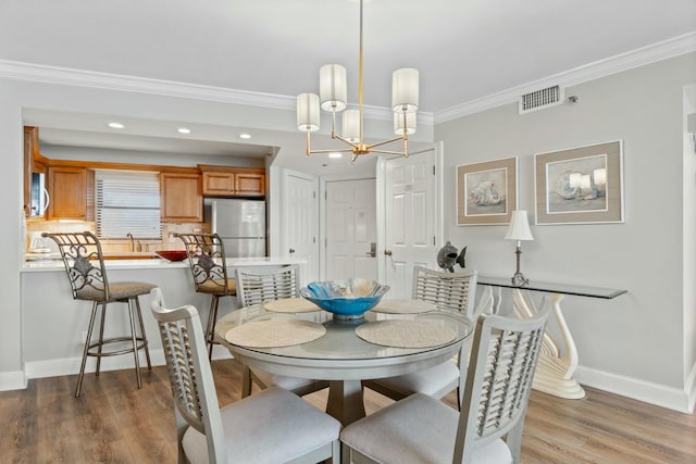 dining area with recessed lighting, wood finished floors, visible vents, baseboards, and crown molding