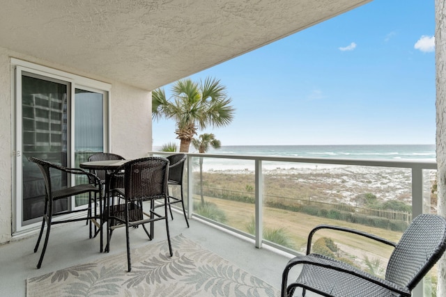 balcony featuring a water view and a view of the beach