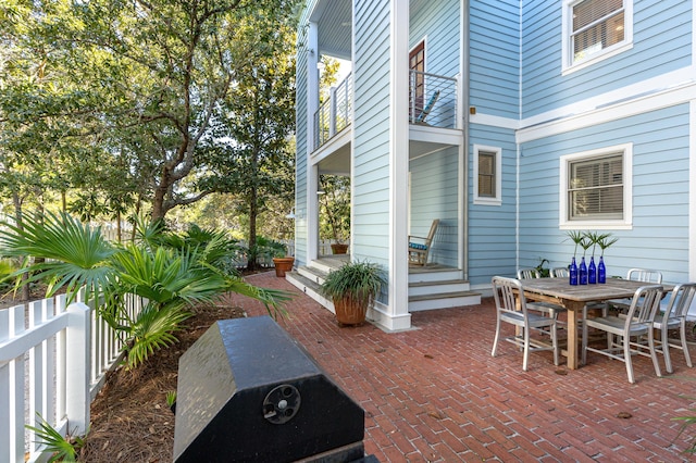 view of patio / terrace with outdoor dining space, fence, and a balcony