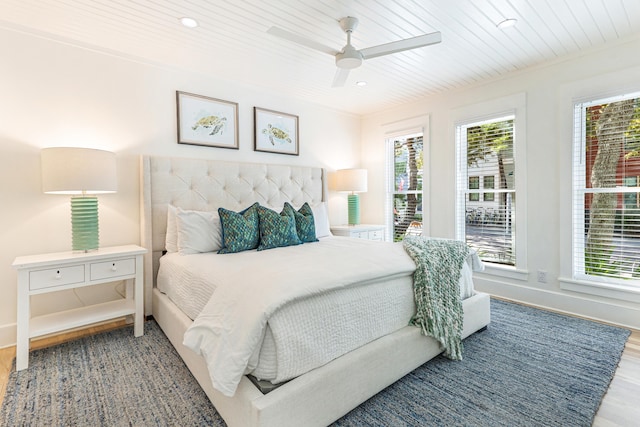 bedroom featuring multiple windows, wooden ceiling, wood finished floors, and baseboards