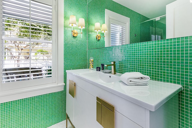 bathroom featuring a stall shower, vanity, and tile walls