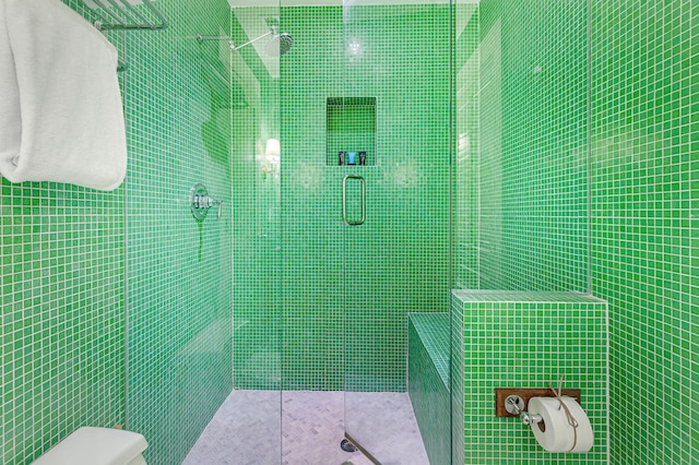 bathroom featuring toilet and a tile shower