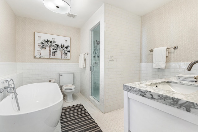 bathroom featuring tile walls, visible vents, a freestanding bath, a stall shower, and tile patterned floors