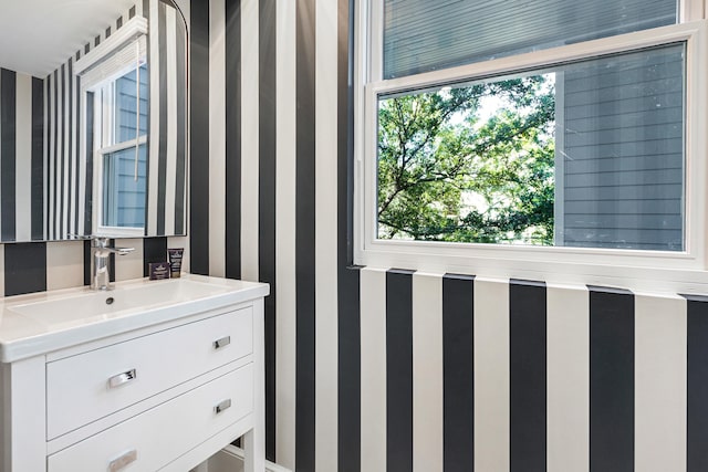 bathroom featuring vanity and wallpapered walls