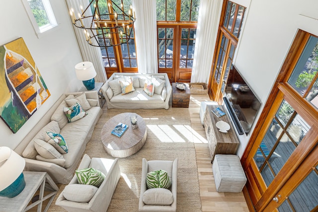 living area featuring a chandelier, wood finished floors, and french doors