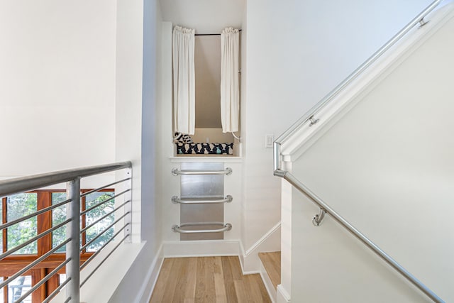 staircase with baseboards and wood finished floors