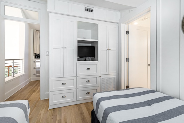 bedroom featuring baseboards, light wood-style flooring, visible vents, and a closet