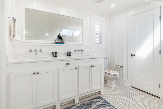 full bathroom featuring visible vents, a sink, toilet, and double vanity