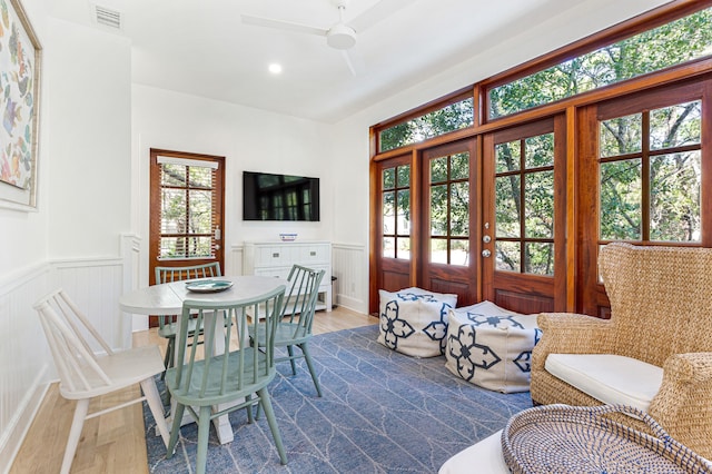 dining area featuring ceiling fan, wainscoting, wood finished floors, and visible vents