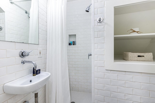 bathroom with a stall shower and a sink