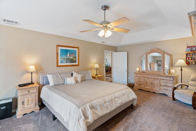 bedroom featuring visible vents, ceiling fan, a tray ceiling, a textured ceiling, and carpet floors