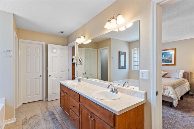 ensuite bathroom with a bath, double vanity, and a sink