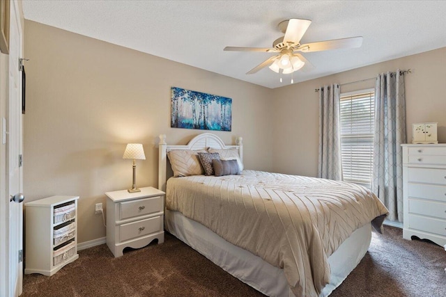 bedroom with a ceiling fan, dark carpet, a textured ceiling, and baseboards