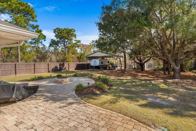 view of yard with a fire pit, a patio, and fence