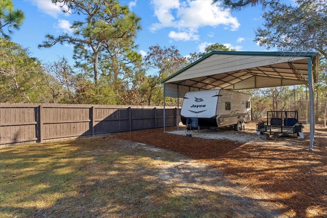 view of yard featuring a carport and fence