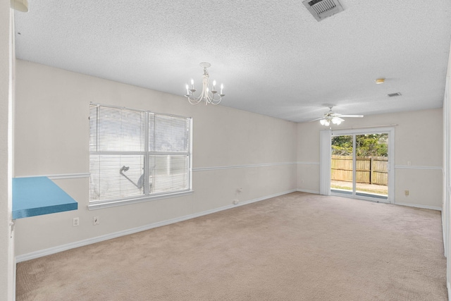 spare room featuring carpet floors, visible vents, a textured ceiling, and baseboards