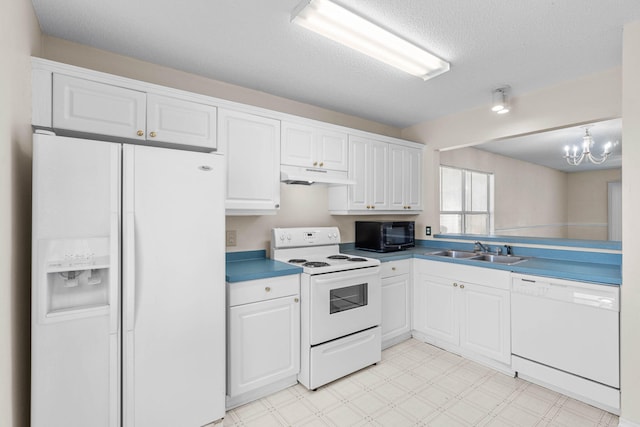 kitchen with light floors, white cabinets, a sink, white appliances, and under cabinet range hood