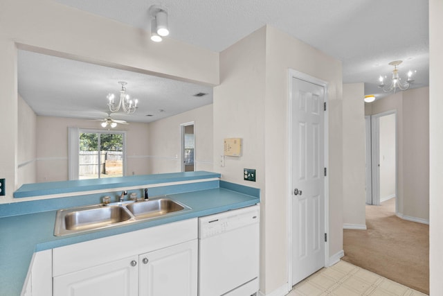 kitchen with white dishwasher, a sink, white cabinets, and a notable chandelier