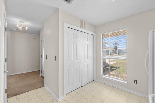 interior space featuring light floors, baseboards, a notable chandelier, and freestanding refrigerator