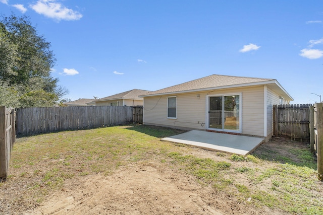 back of property with a fenced backyard, a patio, and a lawn