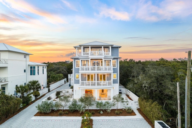 view of front of property with fence and a balcony