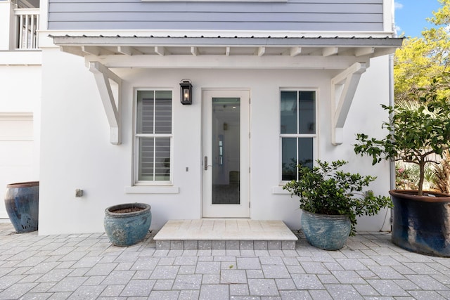 property entrance featuring a patio area and stucco siding