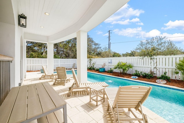 view of swimming pool with a fenced in pool, a fenced backyard, and a patio