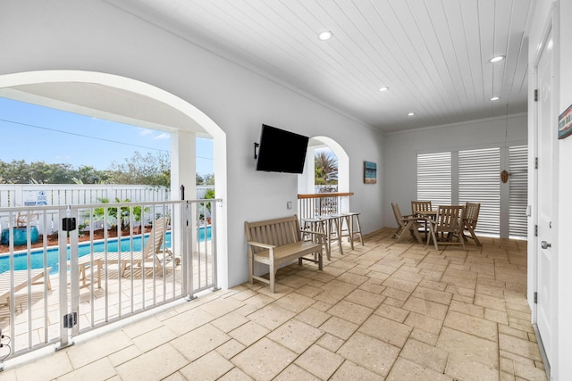 interior space with fence, outdoor dining area, and a fenced in pool